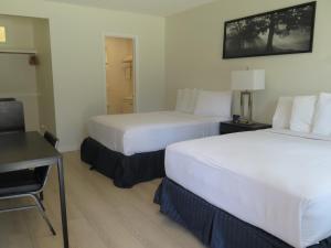 Una habitación de hotel con dos camas y un escritorio. en DTLA Hotel, en Los Ángeles