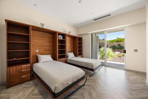 two beds in a room with a window at The Desert Wellness Compound in Palm Desert +76 photos