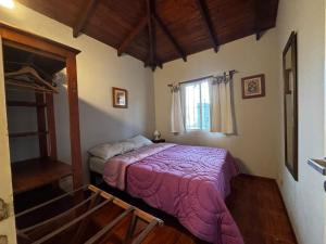 a bedroom with a bed with a purple blanket at Family Home en Costa Azul in Costa Azul