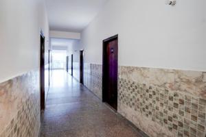 a hallway with tile walls and a door at Hotel O Star Key Inn in Sohna