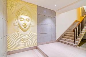 a mural of a giant buddha on the wall in a hallway at Super Hotel O SAMOTEL in kolkata