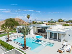 an aerial view of a house with a swimming pool and palm trees at The Desert Wellness Compound in Palm Desert