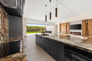 a kitchen with black cabinets and a large counter top at The Desert Wellness Compound in Palm Desert