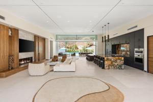 an open living room with white furniture and a fireplace at The Desert Wellness Compound in Palm Desert
