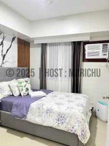 a bedroom with a bed with purple and white sheets at AVIDA TOWERS RIALA 2BR Condo in IT Park Cebu City in Carreta +36 photos