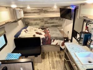 une petite chambre dans un camping-car avec un lit dans l'établissement Cozy RV Oasis Farm Stay with Hot Tub Free WiFi and Coffee 5 Min to Adventist Health and Redbud Park, à Clearlake 25 autres photos