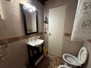 a bathroom with a toilet and a sink and a mirror at Family Home en Costa Azul in Costa Azul