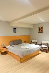 Un dormitorio con una cama grande y dos sillas. en ImHoteP Hotel, en El Cairo