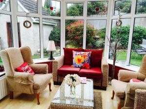 a living room with a red couch and windows at Tara Lodge Galway in Galway