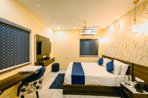 a bedroom with a bed and a flat screen tv at Livotel Premium Hotel in Bhubaneshwar