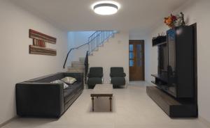uma sala de estar com um sofá e uma televisão e escadas em Casa 3 qtos 2 salas Área P Churrasco Vila Mariana - Klabin em São Paulo