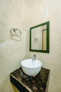 a bathroom with a white sink and a mirror at Livotel Premium Hotel in Bhubaneshwar +101 photos