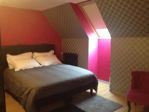 1 dormitorio con cama y pared de color rosa en Beluga, en La Godivelle