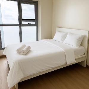 a bedroom with a white bed with two towels on it at Modern Seaview 1BR Near Okada Manila Bay Airport 17 in Manila