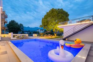 a pool with two rubber ducks in a swimming pool at Flower Hotel Jiuhuashan Blossoms Not Yet Full in Chizhou