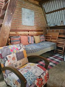 a room with a couch with pillows on it at Chalé Aconchegante, Tapiraí-SP in Tapiraí