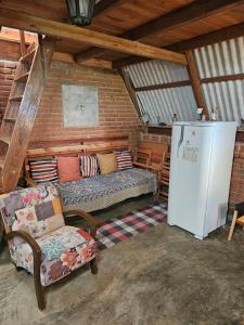 a living room with a couch and a refrigerator at Chalé Aconchegante, Tapiraí-SP in Tapiraí +16 photos