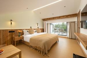 a bedroom with a large bed and a balcony at Flower Hotel Jiuhuashan Blossoms Not Yet Full in Chizhou +94 photos