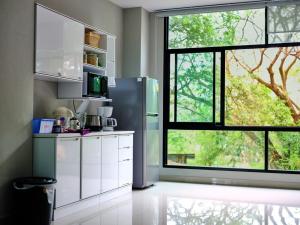 a kitchen with a refrigerator and a large window at Family room in Baan Pakdi Pattaya in Pattaya Central