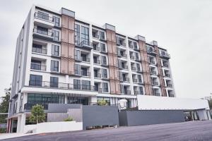 a large apartment building in front of a parking lot at Family room in Baan Pakdi Pattaya in Pattaya Central