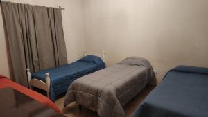 a hospital room with two beds and a curtain at Depto Emma in Fiambala
