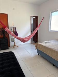 a room with a bed and a hammock in it at Casa de praia Paracuru in Paracuru