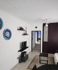 a living room with a couch and a tv on a wall at Vanilla Lee in Richards Bay