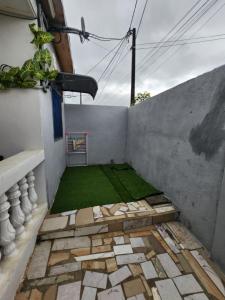 ein kleiner Innenhof mit einem grünen Rasen an einer Wand in der Unterkunft CRYSTAL Azur Gabon in Libreville