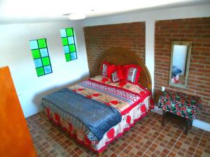 ein Schlafzimmer mit einem Bett in einer Ziegelwand in der Unterkunft El Bello Jardín de Chela in Guanajuato