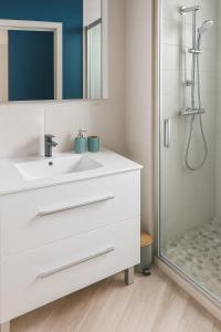 Un baño blanco con lavabo y ducha. en Villa bel azur, en La Trinité