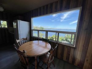 une table et des chaises dans une pièce avec une grande fenêtre dans l'établissement 2-bedroom Waterfront Cottage in Georgian Bay - Rockwood #7, à Dillon
