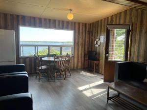 un salon avec une table et des chaises et une fenêtre dans l'établissement 2-bedroom Waterfront Cottage in Georgian Bay - Rockwood #7, à Dillon