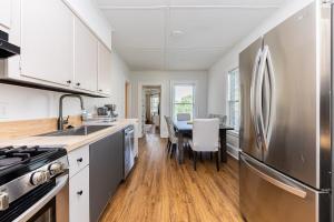 a kitchen with a stainless steel refrigerator and a table at Spacious 3BR Family Flat Near Encore Assembly Row in Somerville