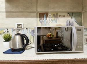 a microwave oven on a counter with a tea kettle at 2 Bedroom Modern Flat at Zayed in 6th Of October