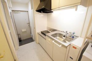 a small kitchen with a sink and a refrigerator at アイホームマキシ 4b in Asato