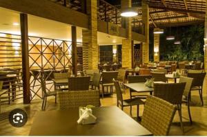 a dining room with tables and chairs and a restaurant at RM Beach Paradise - Barra Iloa Residense in Barra de São Miguel