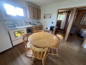 une cuisine avec une table, des chaises et une cuisinière dans l'établissement 3-bedroom Cottage in Georgian Bay - Rockwood #10, à Dillon