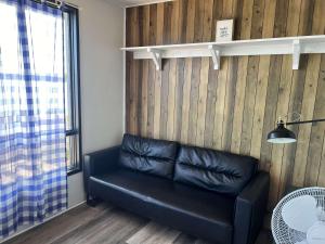 un canapé en cuir noir dans une pièce avec une fenêtre dans l'établissement Lakeview Cabin in Georgian Bay - Rockwood #11, à Dillon