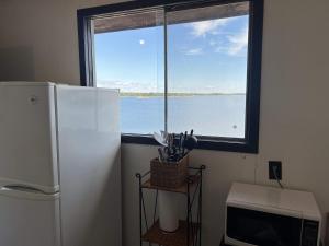 Il comprend une cuisine équipée d'un réfrigérateur et une grande fenêtre. dans l'établissement Lakeview Cabin in Georgian Bay - Rockwood #11, à Dillon