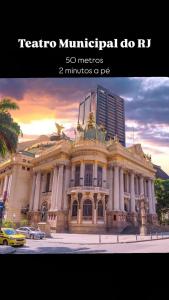a large building on a street with a yellow taxi at Coração da Lapa no Centro RJ com Vaga in Rio de Janeiro