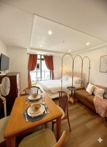 Un dormitorio con una cama y una mesa y sillas. en Top Baguio Staycation Near City, en Baguio