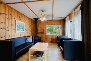 un salon avec des fauteuils en cuir et un mur en bois dans l'établissement 2-Bedroom Cottage #2 - Sand Bay, à Dillon