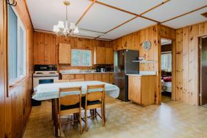 - une cuisine avec des murs en bois, une table et des chaises dans l'établissement 2-Bedroom Cottage #2 - Sand Bay, à Dillon
