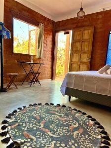 Un dormitorio con una cama y una alfombra en el suelo. en Vila Kuir Hospedagens, en Alto Paraíso de Goiás