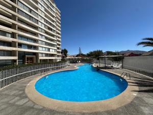 a large swimming pool in front of a building at Departamento en condominio Los Carrera 2092 a pasos casino Antay in Copiapó