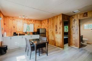 - une cuisine avec des murs en bois, une table et des chaises dans l'établissement 2-Bedroom Cottage #6 - Sand Bay, à Dillon
