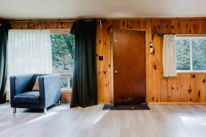 un salon avec une chaise bleue et une porte dans l'établissement 2-Bedroom Cottage #6 - Sand Bay, à Dillon 6 autres photos