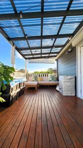 Una terraza con pérgola con una cama y un sofá. en Charming Cottage Retreat Penrith, en Penrith