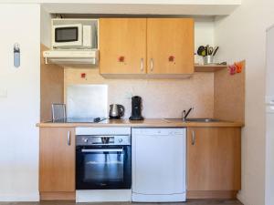 a small kitchen with a stove and a microwave at Appartement 8 Pers. à Peyragudes avec Piscine Intérieure - FR-1-695-86 in Germ +6 photos
