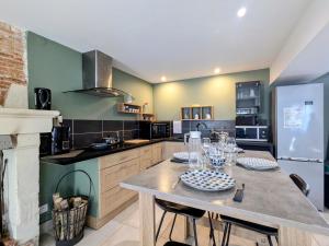 une cuisine avec une table avec des chaises et un réfrigérateur dans l'établissement Evasion et nature près de Châteauroux, logez au cœur du Berry - FR-1-591-763, à Meunet-Planches